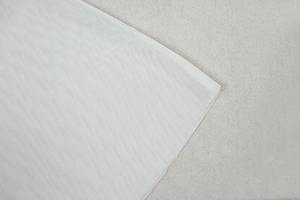 Detail shot of white semi-transparent mesh fabric showing thin texture and fine grid pattern