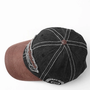 Detail of vintage baseball cap featuring denim patchwork and suede brim with contrast stitching