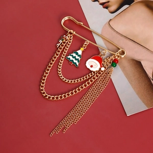 Detail of Christmas tassel brooch with Santa, tree, and candy cane charms on red background