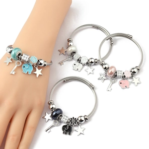 Detailed close-up of woven steel bracelets with colorful elephant and star charms