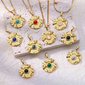 Detail of vintage gold sunburst pendants featuring colorful natural stone centers