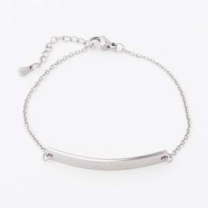 Close-up of a mirror-polished curved bar link on a minimalist adjustable silver-tone bracelet
