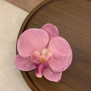Macro shot of realistic pink Phalaenopsis orchid hair clip with detailed flower petals