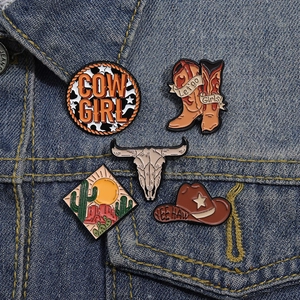 Detailed view of western cowboy enamel pins set pinned on a denim jacket pocket