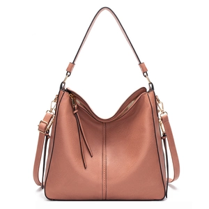 Detail of orange-pink PU leather hobo bag showing vertical stitching and gold zipper closure