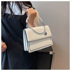 Detail shot of white PU leather square bag with metal chain strap and fashion text