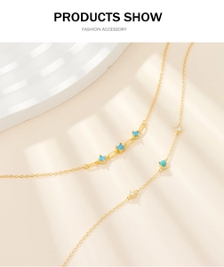 Detailed macro view of a gold chain necklace featuring turquoise and zircon stones
