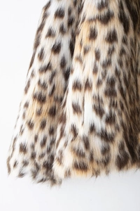 Detailed close-up showing the soft leopard print faux fur texture and pattern of the jacket
