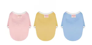 Detailed close-up of pink, yellow, and blue pet cotton vests with bear logo labels