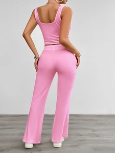 Rear view of pink yoga set featuring a sleeveless top and flared trousers on a model