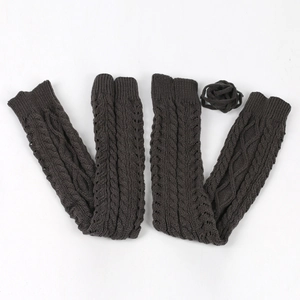 Close-up of cable knit leg warmers in dark coffee with lace-up detail and flower accent