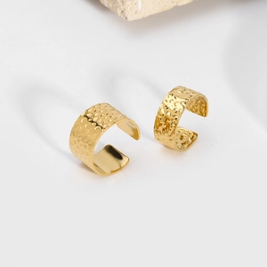 Detail of 18K gold plated C-shape rings with unique hammered texture on white background