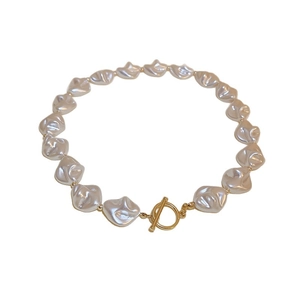 Irregular baroque pearl bracelet with gold toggle clasp on a clean white background