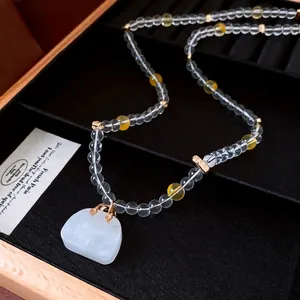 Elegant glass beaded necklace with yellow accents and a polished white stone pendant