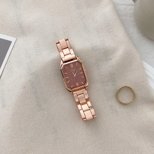 Macro detail of rose gold octagonal quartz watch with textured dial and link bracelet