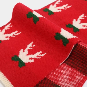 Detailed macro view of red Christmas knit scarf with deer pattern and soft wool texture
