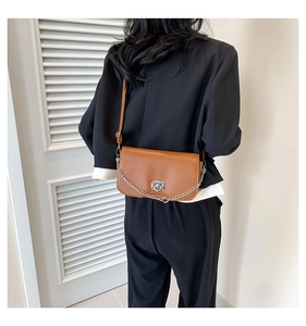 Brown crossbody bag featuring a silver heart-shaped lock and chic chain strap detail