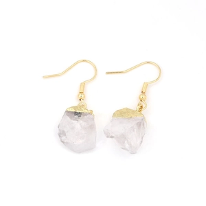 Detailed close-up of natural raw crystal earrings with gold plated hooks and edges