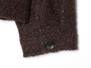 Détail du poignet en fausse fourrure marron avec bouton noir mat sur la veste