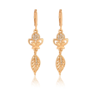 Macro detail of champagne gold butterfly earrings with sparkling cubic zirconia stones