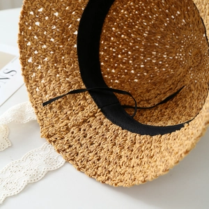 Macro view of woven straw hat interior with sweatband and delicate lace trim detail