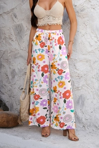Style vacances en plein air montrant un pantalon large floral avec taille haute et cordon