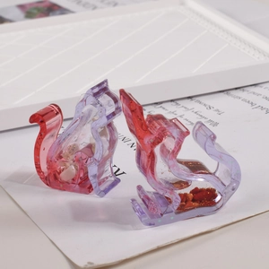 Detailed macro of two purple gradient resin cat figurines with mineral stone infills