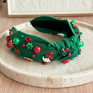 Detail of green knit Christmas headband with red rhinestones and Santa moon pendant
