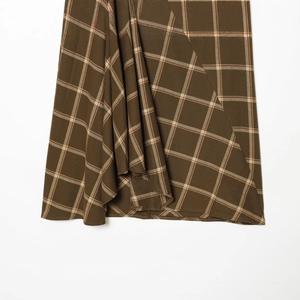Brown plaid midi skirt with asymmetrical panels and tiered tailoring for casual style