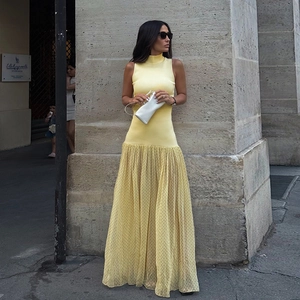 Dettaglio del corpetto in maglia gialla e gonna in tulle a pois su un abito lungo estivo