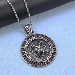 Close-up of vintage silver lion head pendant with embossed details and box chain