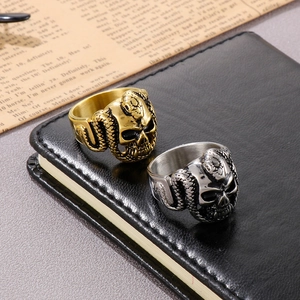 Detailed view of punk skull and snake rings in gold and silver finish on leather
