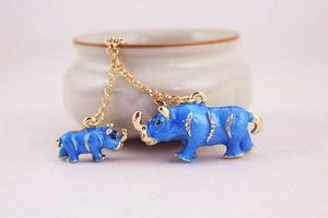 Detail of blue enamel rhinoceros pendants with gold plating and sparkling rhinestones