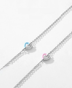 Macro detail of S925 sterling silver heart charms with pink and blue enamel and zircon inlay