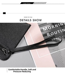 Detail shot of black leather clutch handle with metal rivets and sturdy stitching