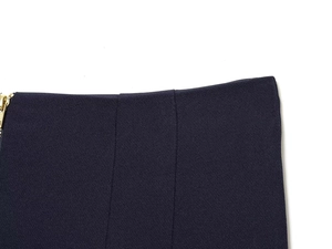 Détails du pantalon bleu marine à taille haute montrant la fermeture éclair dorée et le sergé
