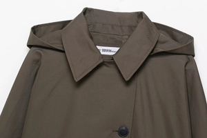 Detailed view of wide lapel hood and single-breasted buttons on khaki trench coat