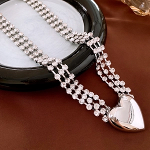 Detailed view of silver triple-layer rhinestone heart waist chain on a plate