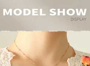 Close-up of minimalist gold beaded choker necklace worn by a model in natural light