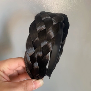 Vista detallada de la diadema de cabello trenzado negro, con textura y estructura realistas.