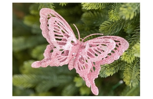 Macro detail of pink glitter butterfly ornament on green pine needles for Christmas decor