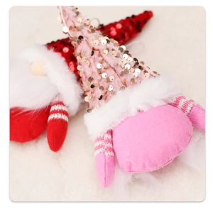 Close-up of sequined Christmas gnome pendants with plush beards and striped arms