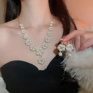 Elegant flower pearl necklace and earrings set with rhinestones on a female model