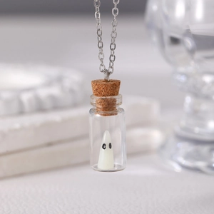 Close-up of a miniature white ghost inside a glass drift bottle pendant with a cork