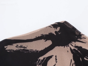 Détail du tissu en maille beige avec motifs noirs abstraits et texture fine