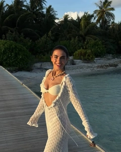 Detailed knit pattern on white crochet beach dress with cut-out waist and long sleeves