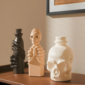 Tre bottiglie gotiche in ceramica con mani di teschio e sculture di scheletro su legno