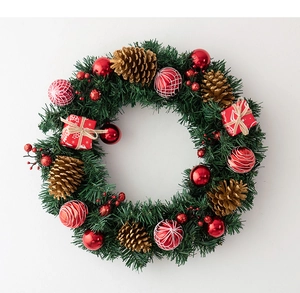 Detailed close-up of a Christmas wreath with red baubles, golden pinecones, and gift boxes