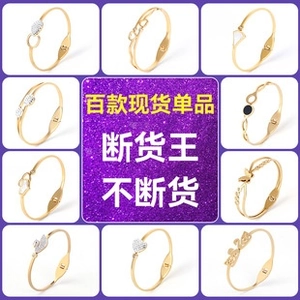 Detail view of assorted gold plated stainless steel spring bracelets with crystal charms