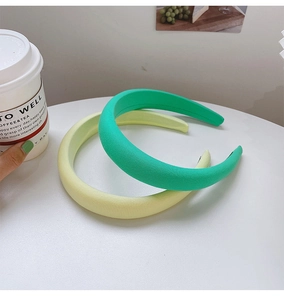 Detail of sponge padded headbands in sage green and cream yellow on white background
